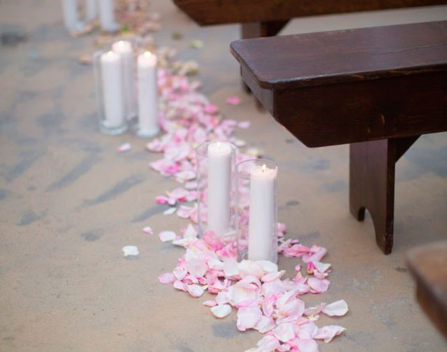 Pétalos y velas para adornar el pasillo de una iglesia para una boda
