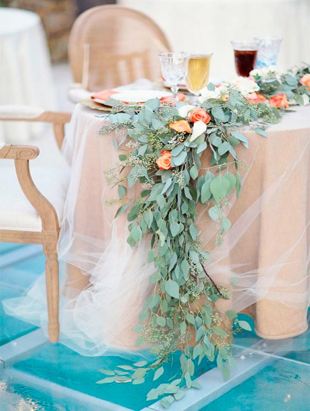 Mesa nupcial con decoración de tul y flores rasas